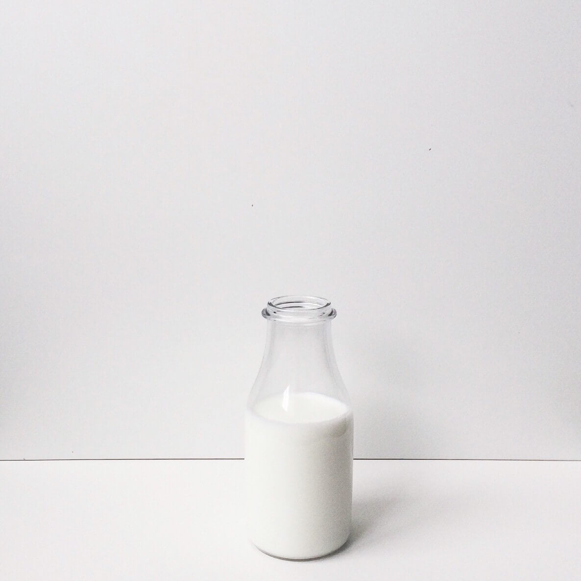 bottle of milk on table with white background