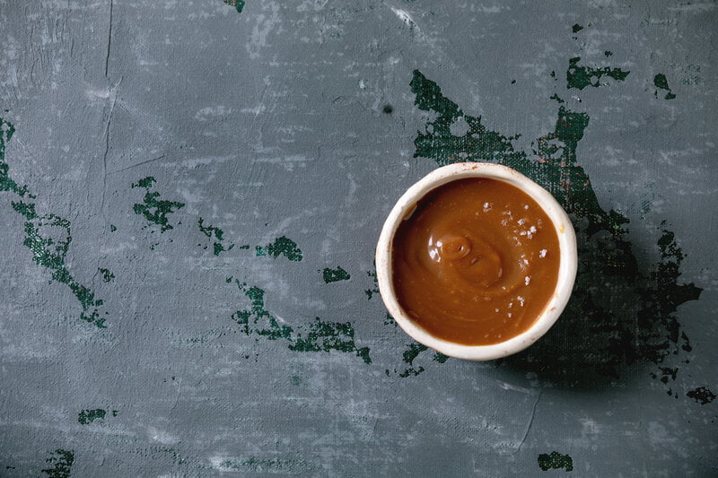 caramel sauce on bowl on stone table