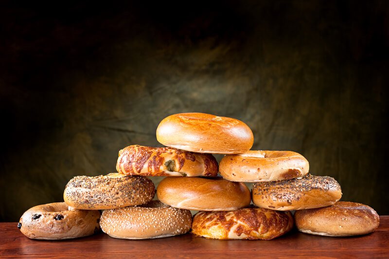 stack of cut bagels on table with black background
