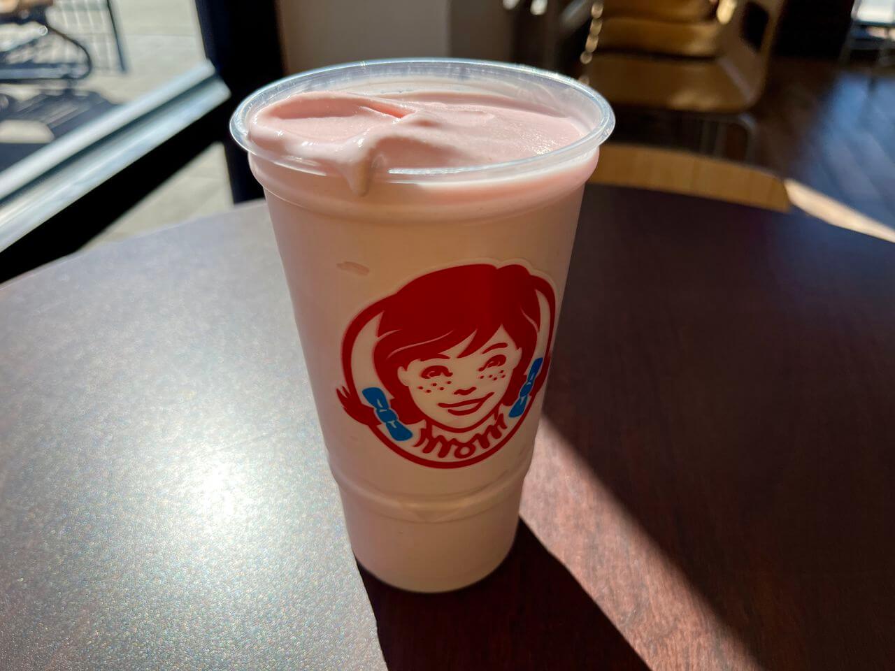 wendys strawberry frosty in clear cup on table