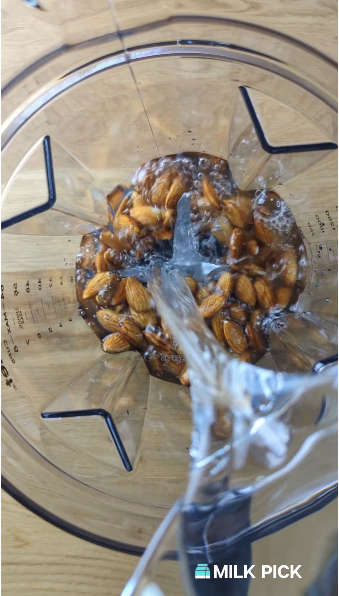 pouring water into blender with almonds
