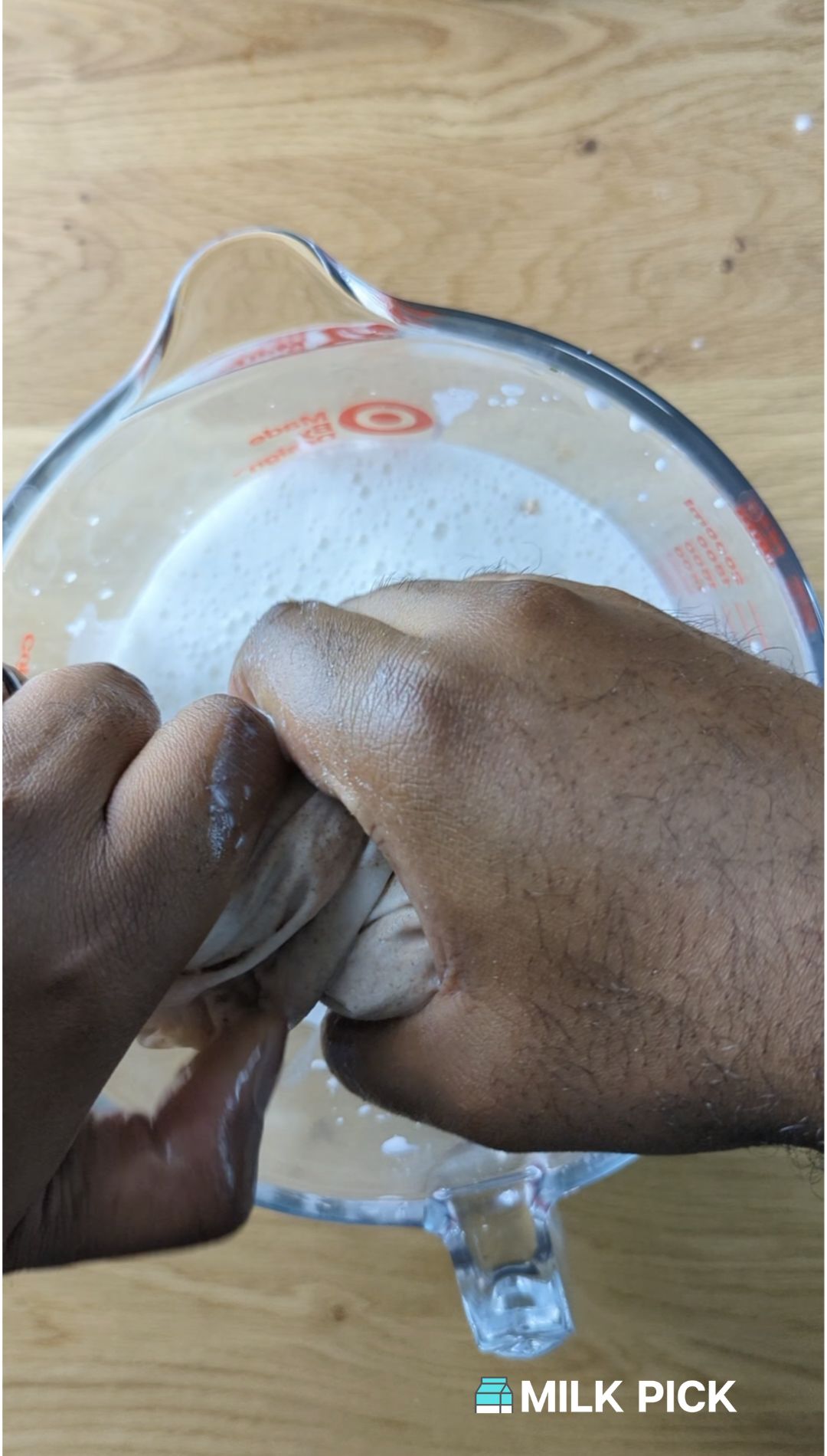 straining vanilla almond milk into container