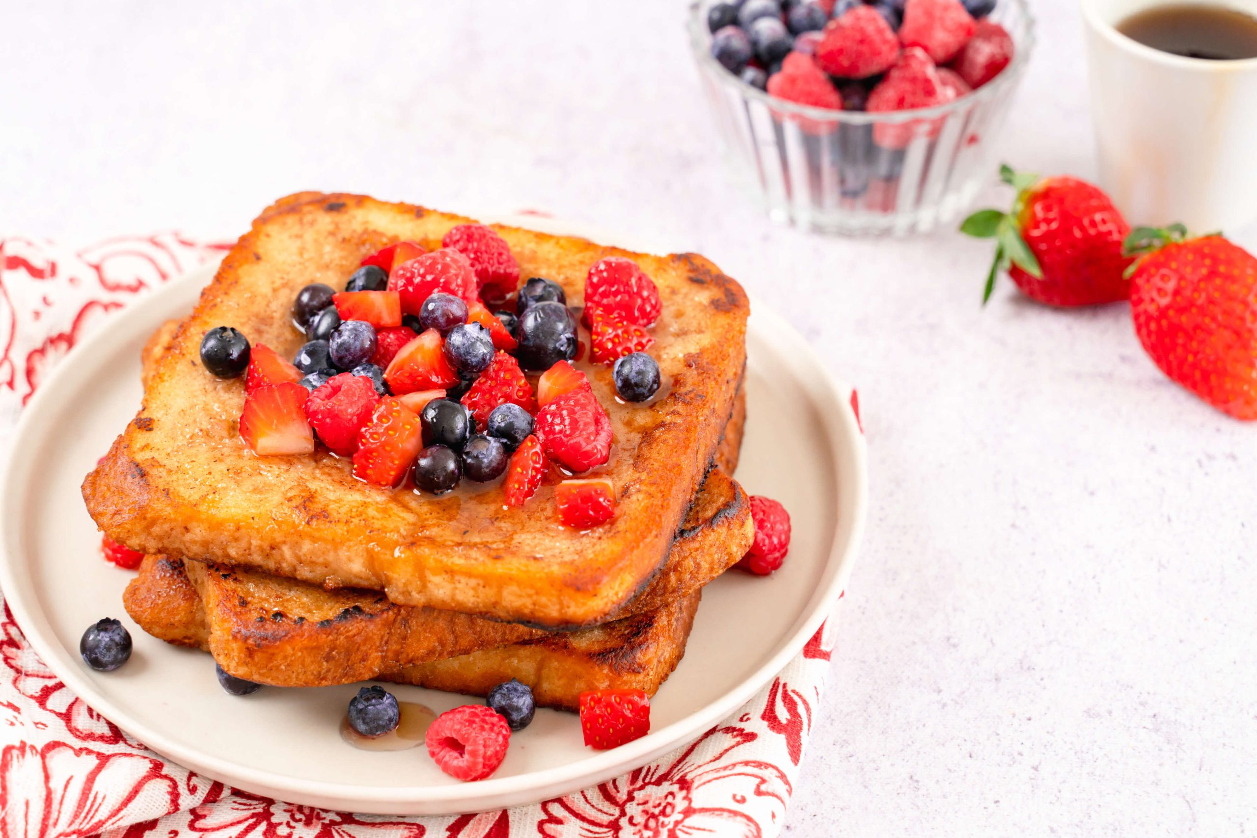 almond milk french toast topped with berries on plate