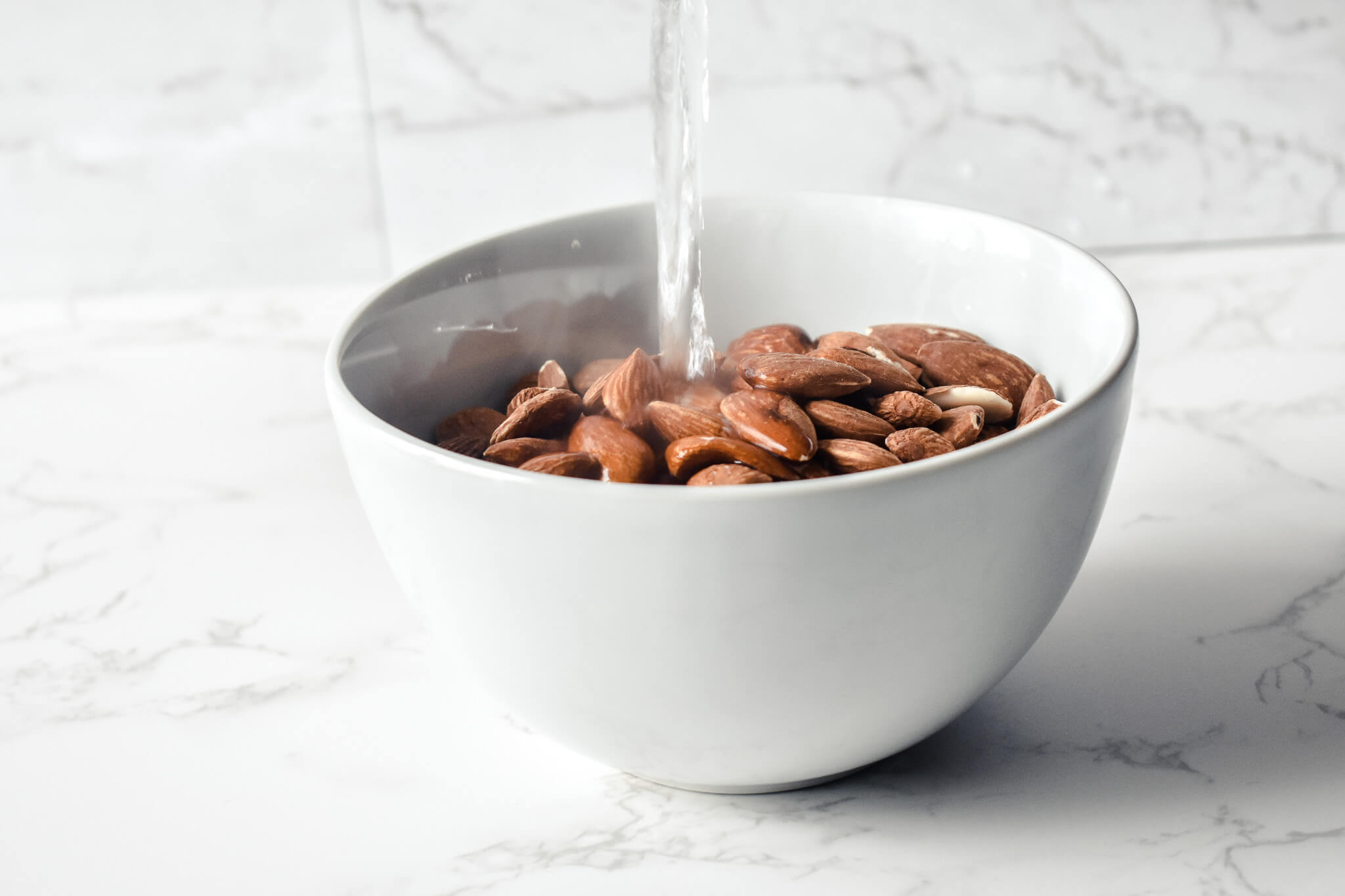 boiling water poured over almonds in bowl