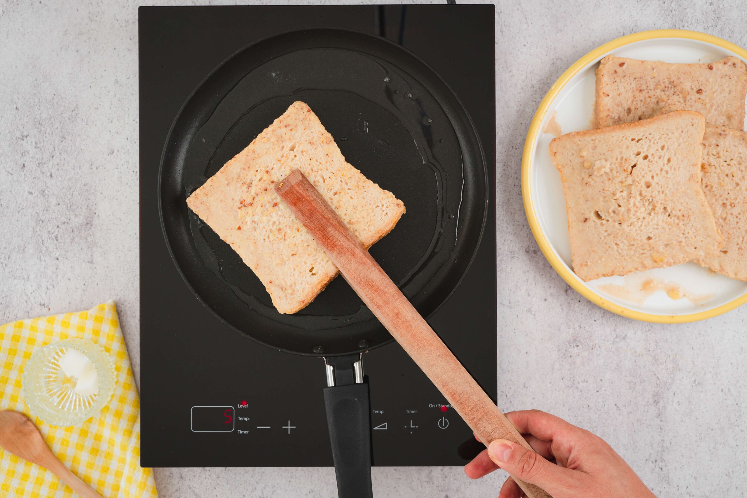 placing almond milk french toast slice on pan