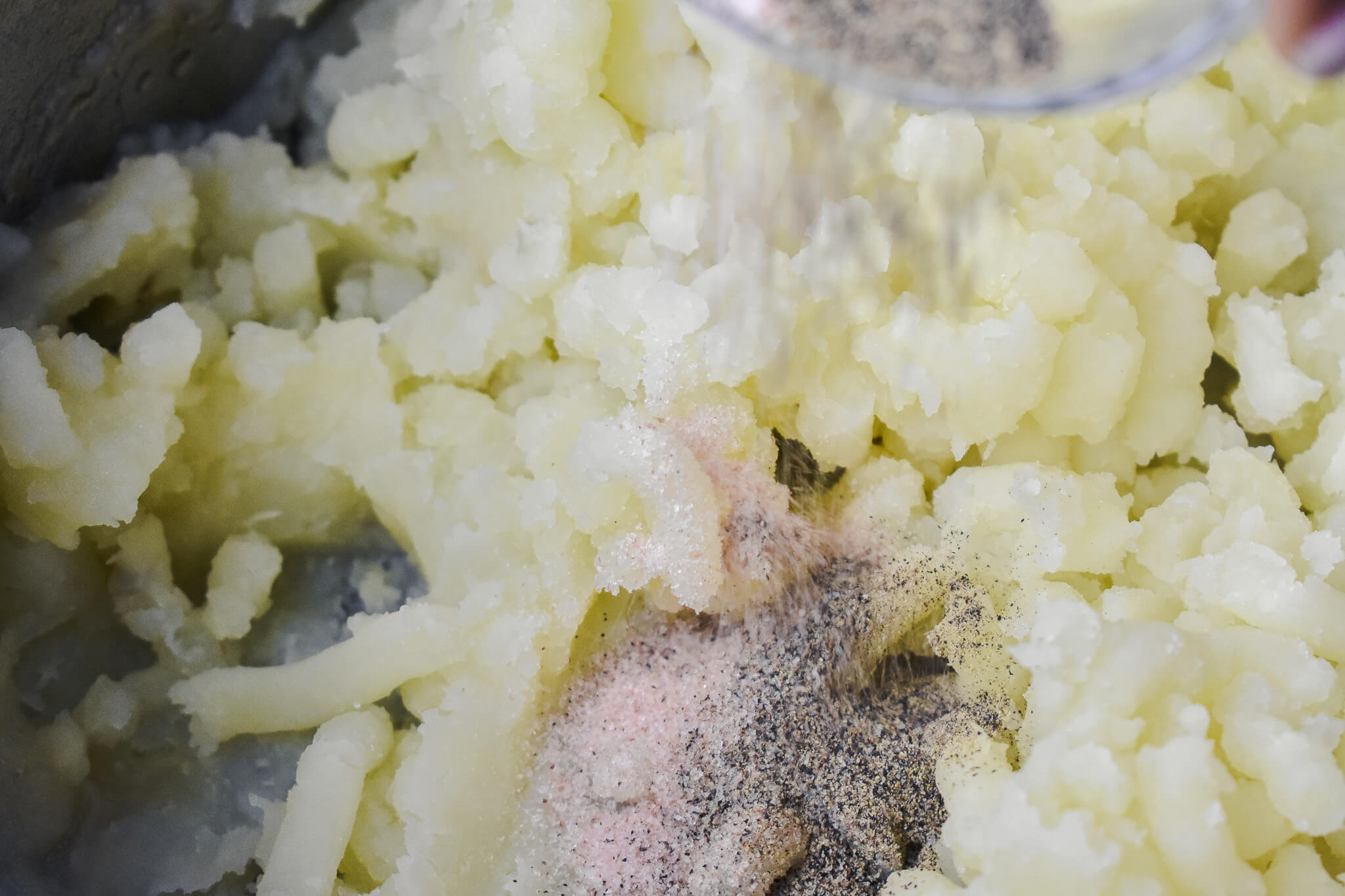 adding salt and pepper to almond milk mashed potatoes