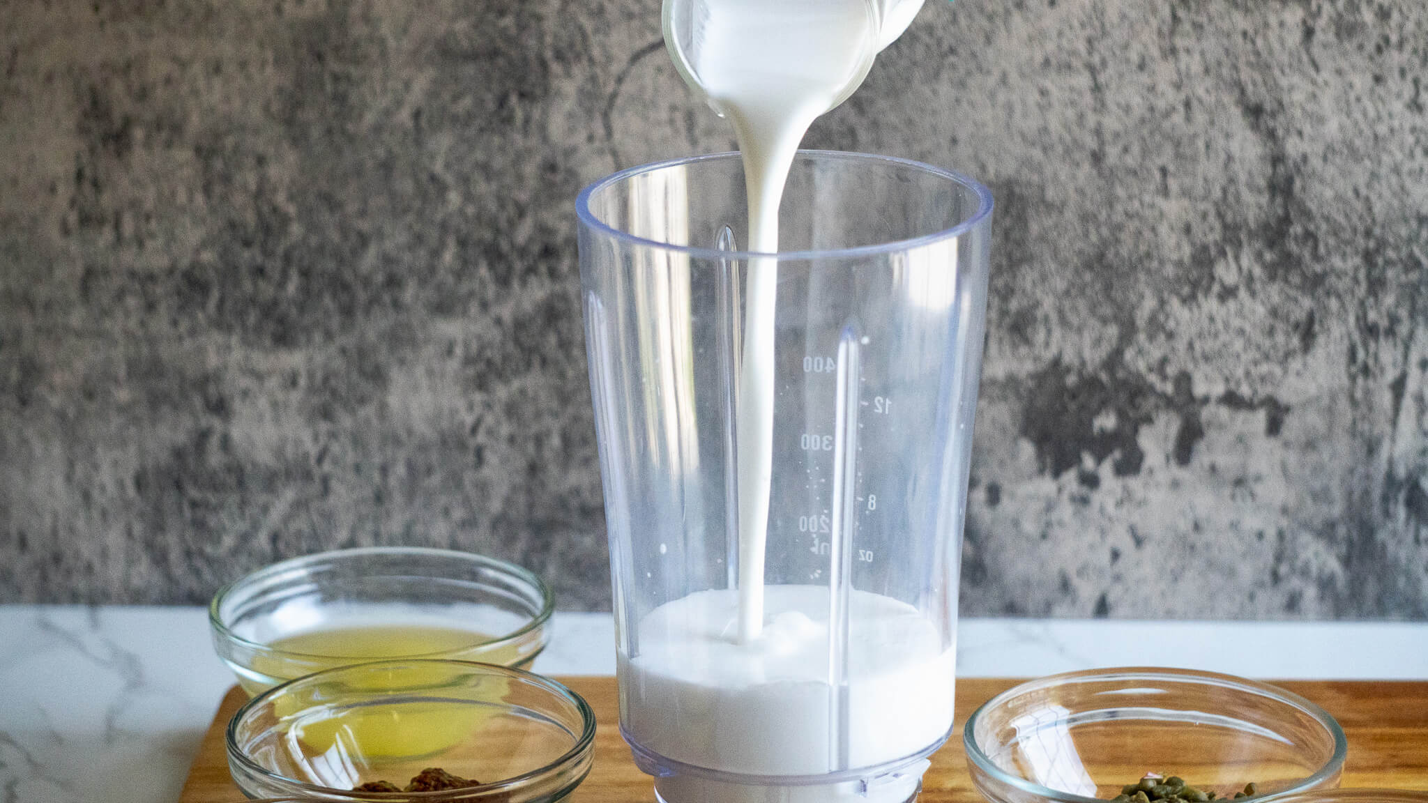 pouring coconut milk in dairy-free caesar dressing