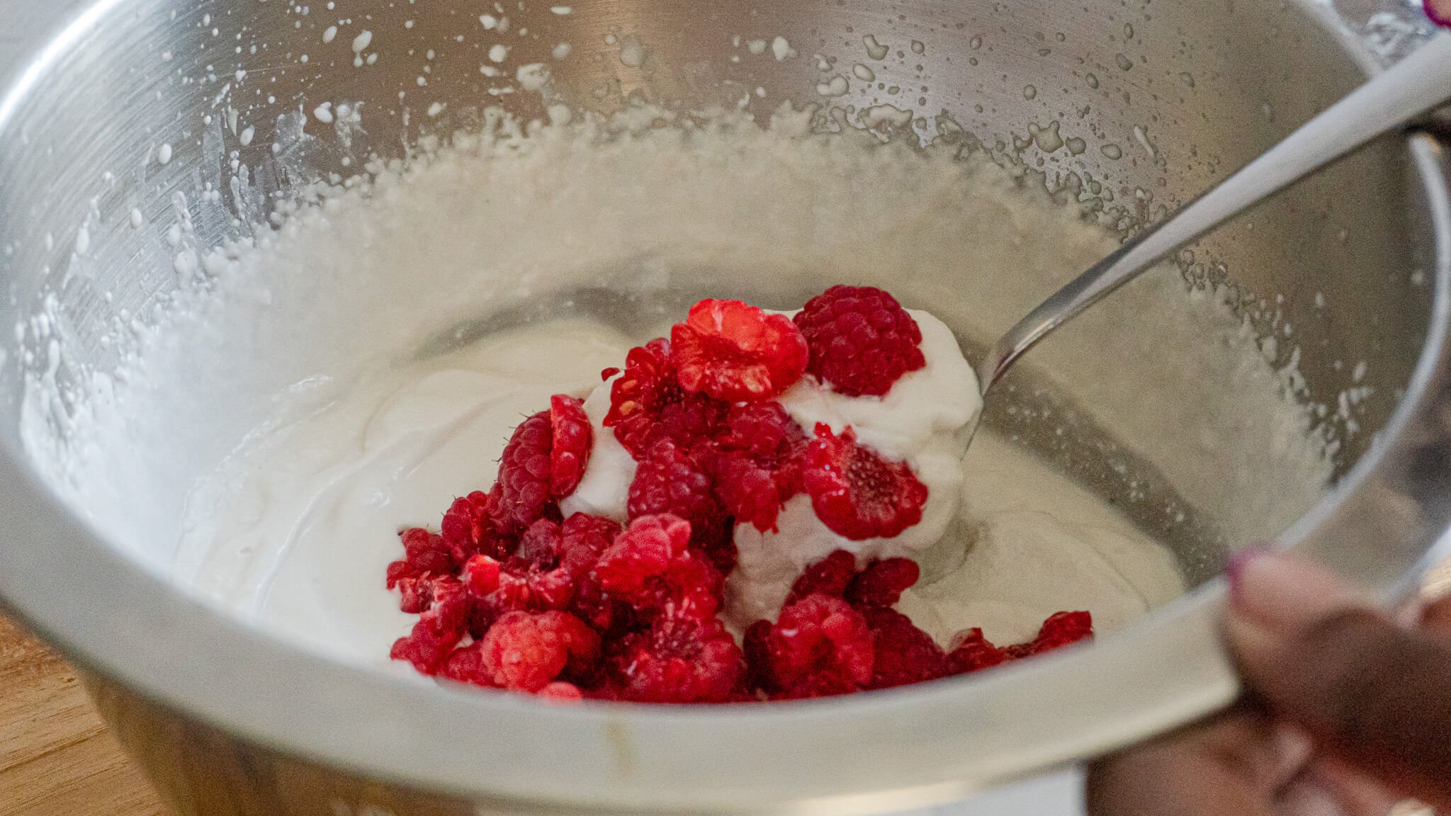 mixing raspberries in non-dairy coconut milk
