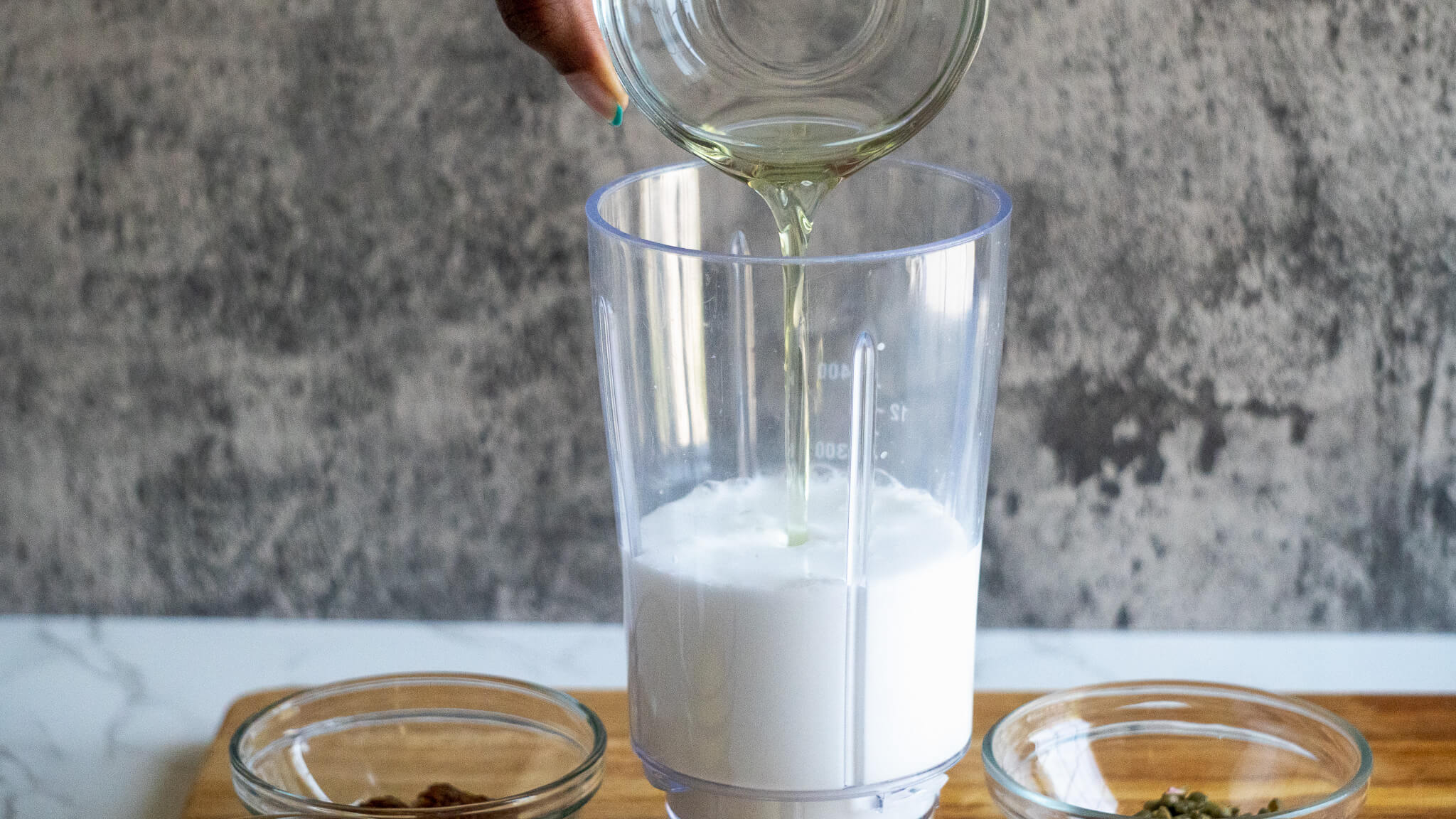 pouring oil in dairy-free caesar dressing
