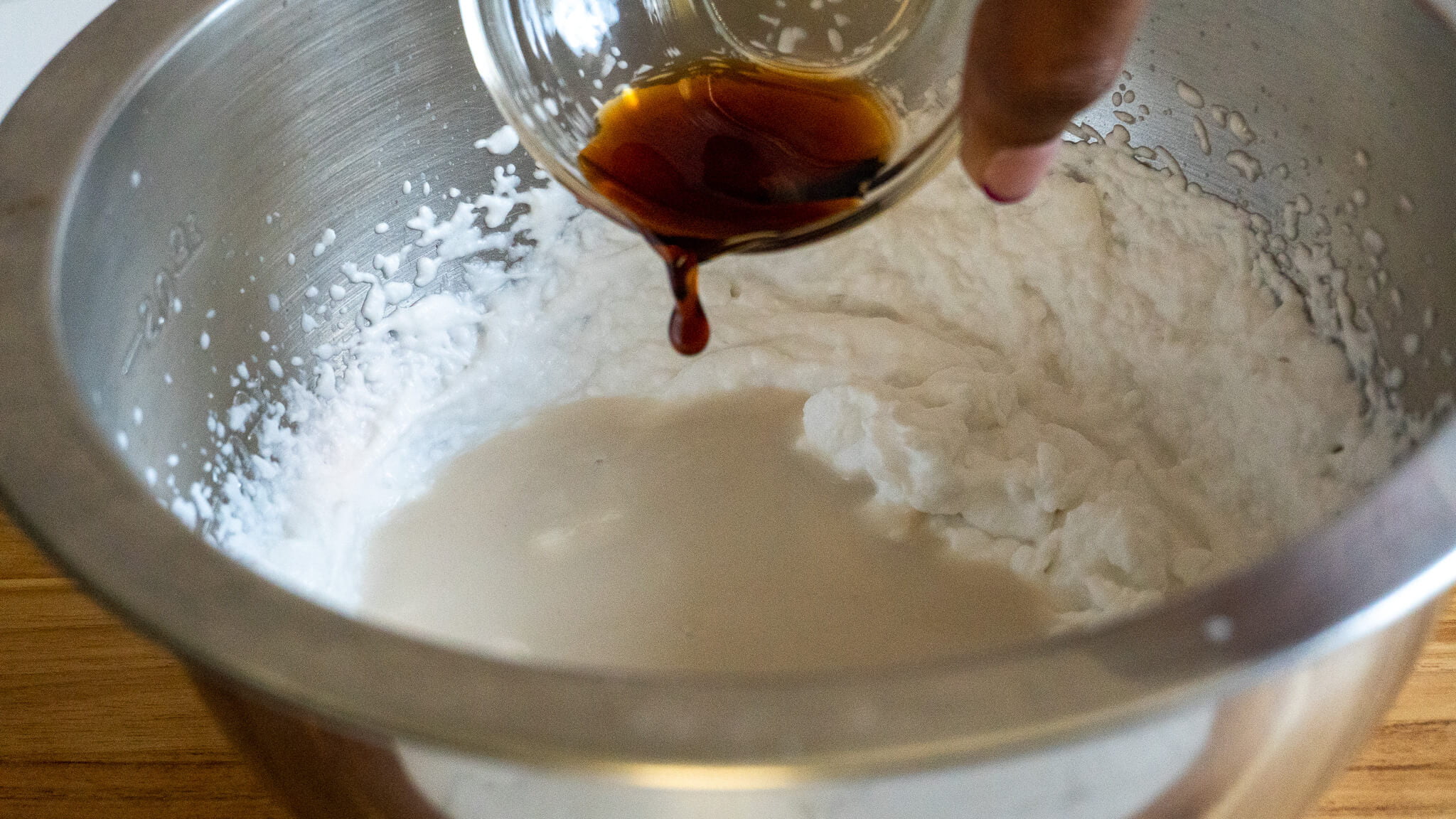pouring vanilla extract into non-dairy ice cream base