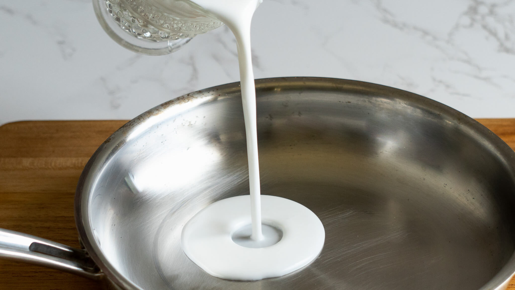 pouring coconut milk into pan