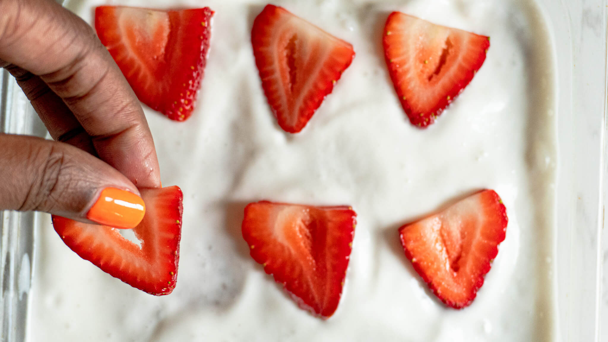 topping dairy-free tres leches cake with strawberries