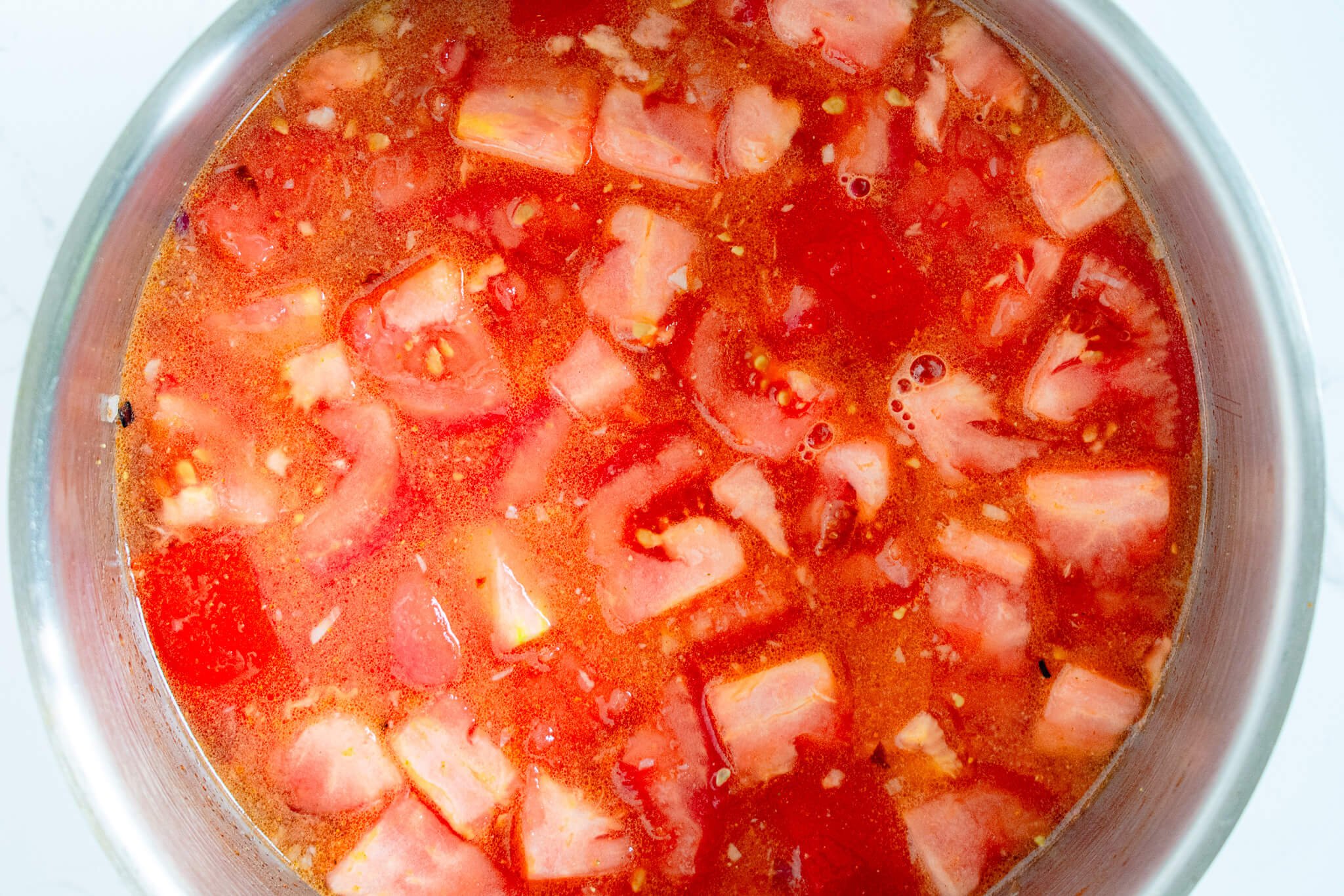 chopped tomatoes and vegetable stock in pot